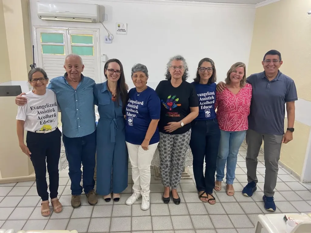 Diretoria da FEJA reunida, vestindo camisetas com o lema Evangelizar, Assistir, Acolher e Educar